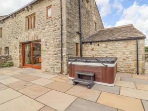 a barbecue on a patio in front of a building at Orcaber Farmhouse in Lancaster