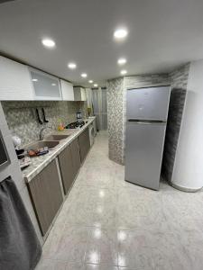 La cuisine est équipée d'un réfrigérateur et d'un évier. dans l'établissement Casa Antonella, à Naples