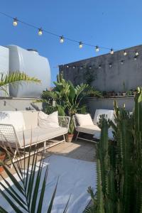 a patio with white couches and cactuses at Homestay in Catania