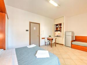 um quarto com uma cama, uma mesa e um frigorífico em Comfy Apartment near Rimini Adriatic Coast with a Sea View em Rimini