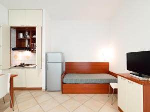 um pequeno quarto com uma cama e um frigorífico em Comfy Apartment near Rimini Adriatic Coast with a Sea View em Rimini