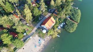 an aerial view of a house and a lake at Przystań Posmakuj in Tereszewo
