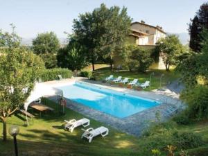 una piscina con sedie a sdraio accanto a una casa di Rustic Holiday Home in Citt di Castello with Swimming Pool a Città di Castello
