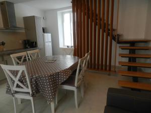 kuchnia ze stołem i krzesłami oraz schody w obiekcie Gîte Utah w mieście Saint-Laurent-sur-Mer