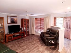 a living room with a couch and a flat screen tv at Welcome to Schnippen Inn. in Tanunda