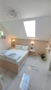 a bedroom with a large bed and a skylight at Pansion Eden in Niš