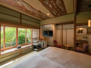 um quarto com uma cama, uma secretária e uma janela em 巛-sen-湯河原 em Yugawara