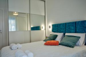 a bedroom with a large white bed with towels on it at The Cosy luxurious Seaside Apartment in Athens