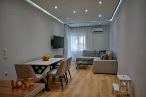 a living room with a table and a couch at The Cosy luxurious Seaside Apartment in Athens