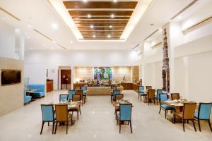 un restaurante con mesas y sillas y un vestíbulo en Lemon Tree Premier 1, Gurugram, en Gurgaon