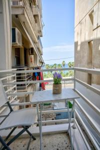 a table and chairs on the balcony of a building at The Cosy luxurious Seaside Apartment in Athens