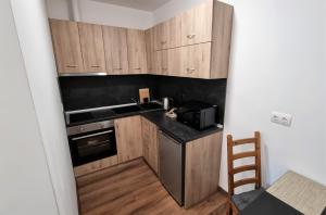 a small kitchen with wooden cabinets and a black counter top at Luxury Quiet Apartment in the City Center in Plovdiv