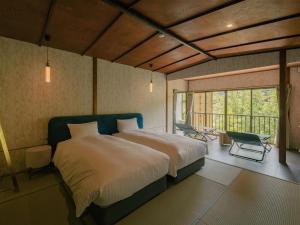 a bedroom with a large bed and a balcony at 巛-sen-湯河原 in Yugawara