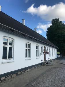 a white building with a cross in front of it at Den Hvide Farm in Skanderborg