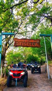 un grupo de cuatro motocicletas estacionadas bajo un cartel en Sant'Elia B&B, en Alessandria del Carretto