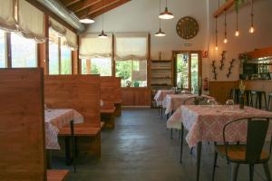 a dining room with tables and chairs and windows at Panticosa Lodge in Panticosa
