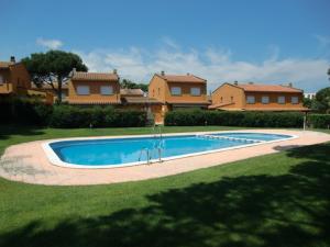 a swimming pool in a yard in front of some houses at Chalet la Fosca in Palamós