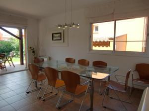 a dining room with a glass table and chairs at Chalet la Fosca in Palamós