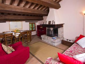 a living room with a red couch and a fireplace at Pretty Holiday Home in Acqualagna with Swimming Pool in Acqualagna