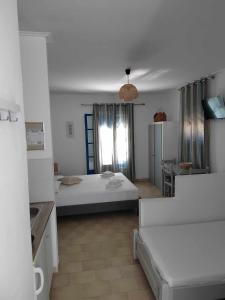 a large room with a bed and a kitchen at Lianos Hotel Apartments in Spetses