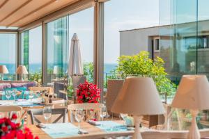 a restaurant with tables and chairs and windows at St. Panteleimon Beach Hotel in Nesebar