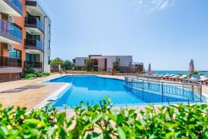 a swimming pool in front of a building with the ocean at St. Panteleimon Beach Hotel in Nesebar