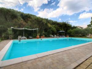 uma grande piscina com uma montanha ao fundo em Country House with swimming pool and garden with Mediterranean plants em Bettona