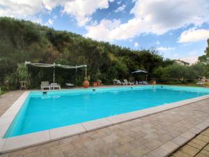 a large swimming pool with a mountain in the background at Country House with swimming pool and garden with Mediterranean plants in Bettona