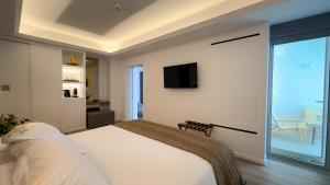 a bedroom with a large bed and a tv at Tasia Maris Beach Hotel - Adults Only in Ayia Napa
