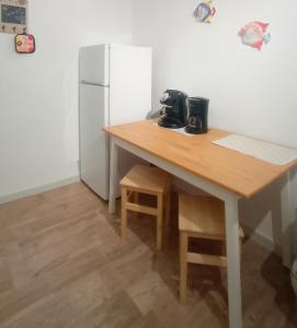 eine Küche mit einem Holztisch und einem Kühlschrank in der Unterkunft LUNA in Monopoli