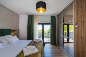 a bedroom with a large bed and a balcony at Holiday house Vito Zadar in Zadar