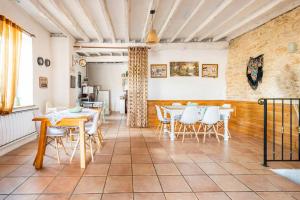 a dining room with white tables and white chairs at La Maison de la Colline in Vers