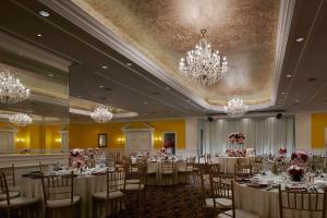 a banquet hall with tables and chairs and chandeliers at The Ritz-Carlton, Kuala Lumpur - TravelEase Visa-Free Getaway in Kuala Lumpur