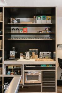 a kitchen with a counter and shelves with appliances at StayLagom in Ballycastle