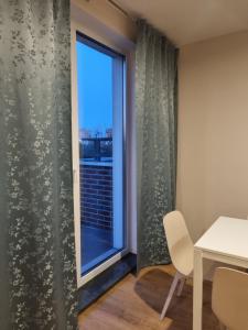 um quarto com uma janela e uma mesa e cadeira em Mieszkanie w centrum miasta. em Gdansk