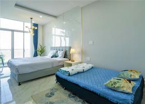 1 dormitorio con 2 camas y lámpara. en Ocean View Studio,Ocean View 3BR-apartment, Sealinks City, Mui Ne, en Phan Thiet