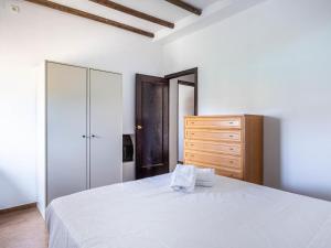 - une chambre avec un lit blanc et une commode en bois dans l'établissement Villa Santa Teresa Vacacional Sevilla, à Dos Hermanas