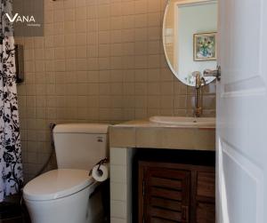 a bathroom with a toilet and a sink and a mirror at VANA Homestay in Ban Tai