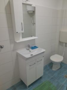 a bathroom with a white sink and a toilet at Guest House Bajceta in Herceg-Novi