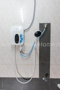 a shower in a bathroom with a hose hooked up at Twenty Seven HomeStay in Cheras