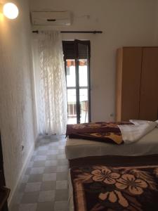 a bedroom with two beds and a window with curtains at Guest House Bajceta in Herceg-Novi