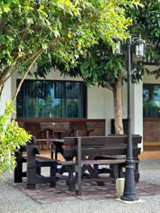 einen Park mit Bänken, einer Laterne und einem Tisch in der Unterkunft Sanaepatan Home Resort - เสน่ห์ป่าตาล โฮม รีสอร์ต in Ban Buak Khang