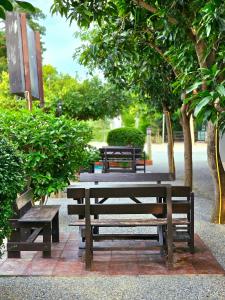 uma mesa de piquenique e bancos num parque com árvores em Sanaepatan Home Resort - เสน่ห์ป่าตาล โฮม รีสอร์ต em Ban Buak Khang