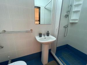 a bathroom with a sink and a mirror and a toilet at Vila Lorena in Mangalia