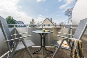a small table on a balcony with two chairs at Likedeeler Weg 1 Whg 24 in Zingst