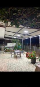 une terrasse avec une table, des bancs et des fleurs dans l'établissement Guest House Bajceta, à Herceg-Novi