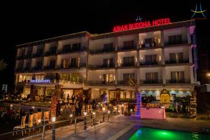 a hotel with a pool in front of it at night at Asian Buddha Hotel in Bhairāhawā