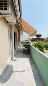- un balcon avec une table et un parasol dans un bâtiment dans l'établissement Silvy's Sunny House, à Platamona