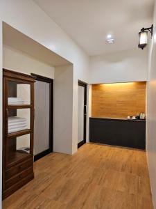 ein leeres Zimmer mit einem Zimmer mit einem Regal und einer Küche in der Unterkunft Sanaepatan Home Resort - เสน่ห์ป่าตาล โฮม รีสอร์ต in Ban Buak Khang