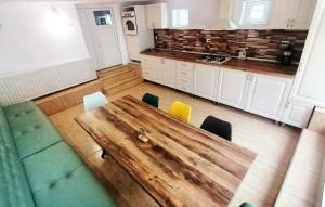 uma vista superior de uma cozinha com uma mesa de madeira e cadeiras em Casa Noastră em Cricău